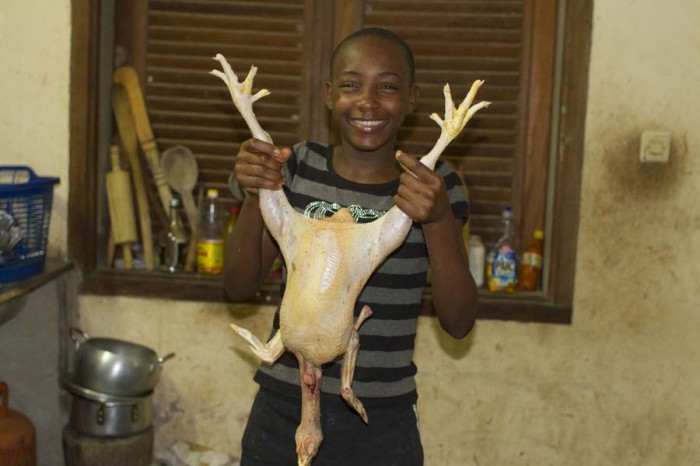My host sister proudly shows off a chicken that was just killed by my older host brother