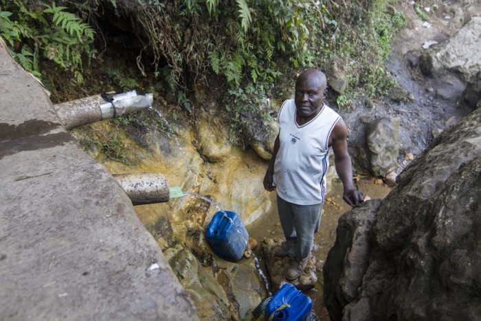 A man fetches water from the water site in Kwen.